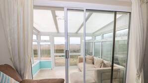 Una habitación con puerta de cristal corredera que da a un patio.