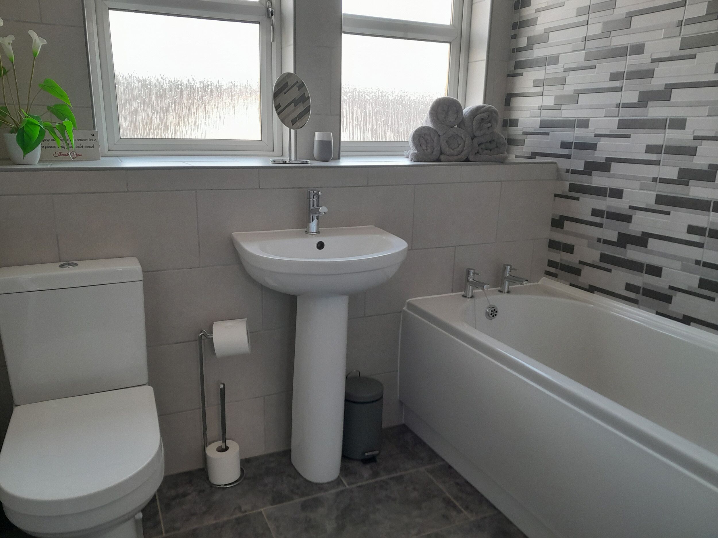 Un bagno moderno con il water, lavabo e vasca da bagno.