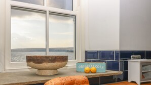 A kitchen with a large window, a stone bowl, a loaf of bread, and a cheese board. - Skyfell (Skipton)