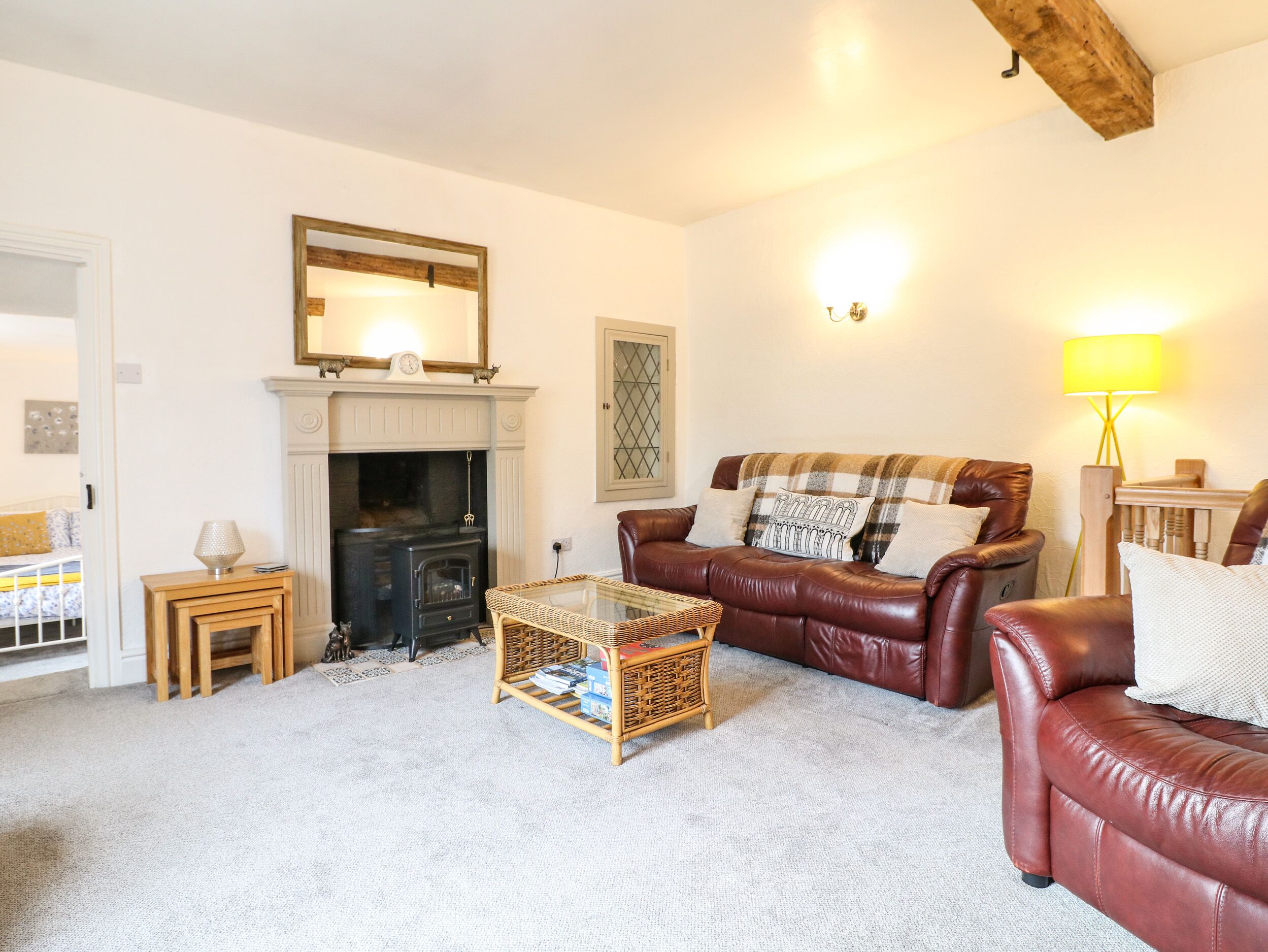 A cozy living room with a fireplace, leather sofa, and a coffee table.