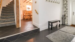 Una scala conduce a una sala da pranzo con sedie e un tavolo in legno.