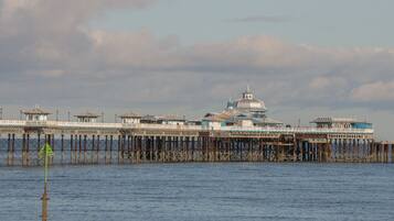 Un muelle que se adentra en el agua, con un gran edificio que cuenta con una cúpula y varias construcciones más pequeñas.