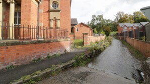 A narrow brick pathway flanked by residential buildings with a canal running alongside. - The Alders (Llanfyllin)