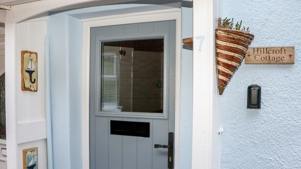 A house number 7, a door with a window, and a sign reading "Hillcroft Cottage".