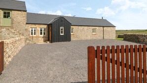 A stone building with a gravel driveway and a wooden gate. - Horsley Cottage (Consett)