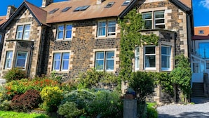A stone building with multiple windows and a sloped roof. - Whinstones at 4 The Villas (Alnwick)