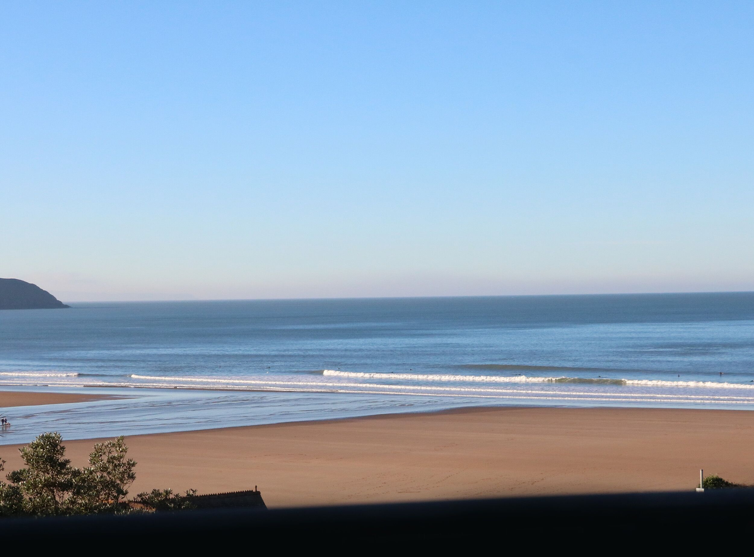 Ein Strand mit blauem Himmel und ruhiger See.