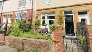 A row of terraced houses with brick and stucco exteriors, some with visible satellite dishes and potted plants. - 4 Ford Street (Durham)