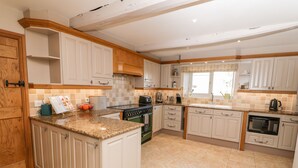 A modern kitchen with white cabinetry, a granite countertop, and a central island.