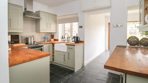 A modern kitchen with light-colored cabinets, a central island, and a view to the outside. - Griff Lodge (York)