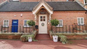 A brick building with a central entrance, a blue door, and a sign reading "Derbyshire House". - Manifold Dale (Ashbourne)