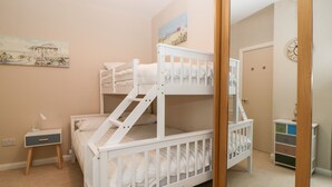 A bunk bed room with a desk and a mirror. - Cove Cottage (Torquay)
