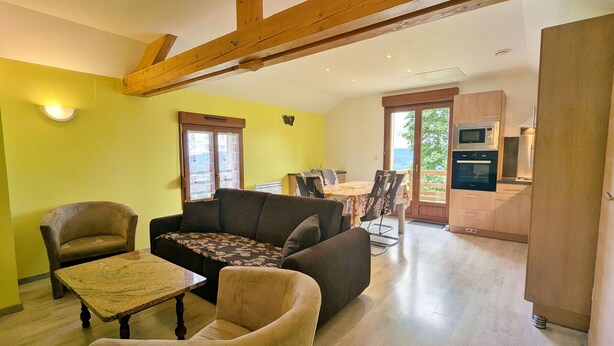 A living room with a sofa, chairs, a dining table, and a kitchen area with cabinets and appliances. - Renovated comfortable house, great view, pets allowed (Gerbamont)