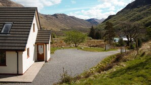 Une maison avec une allée en gravier, une porte en bois et une fenêtre.