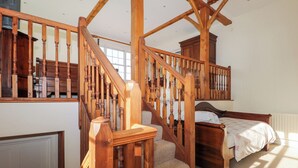 A wooden staircase with a landing leading to a bedroom. - Groomes Country House (Bordon)