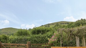 A wooden gate in a rural setting with a hill in the background. - Minton Lane Cottage (Church Stretton)