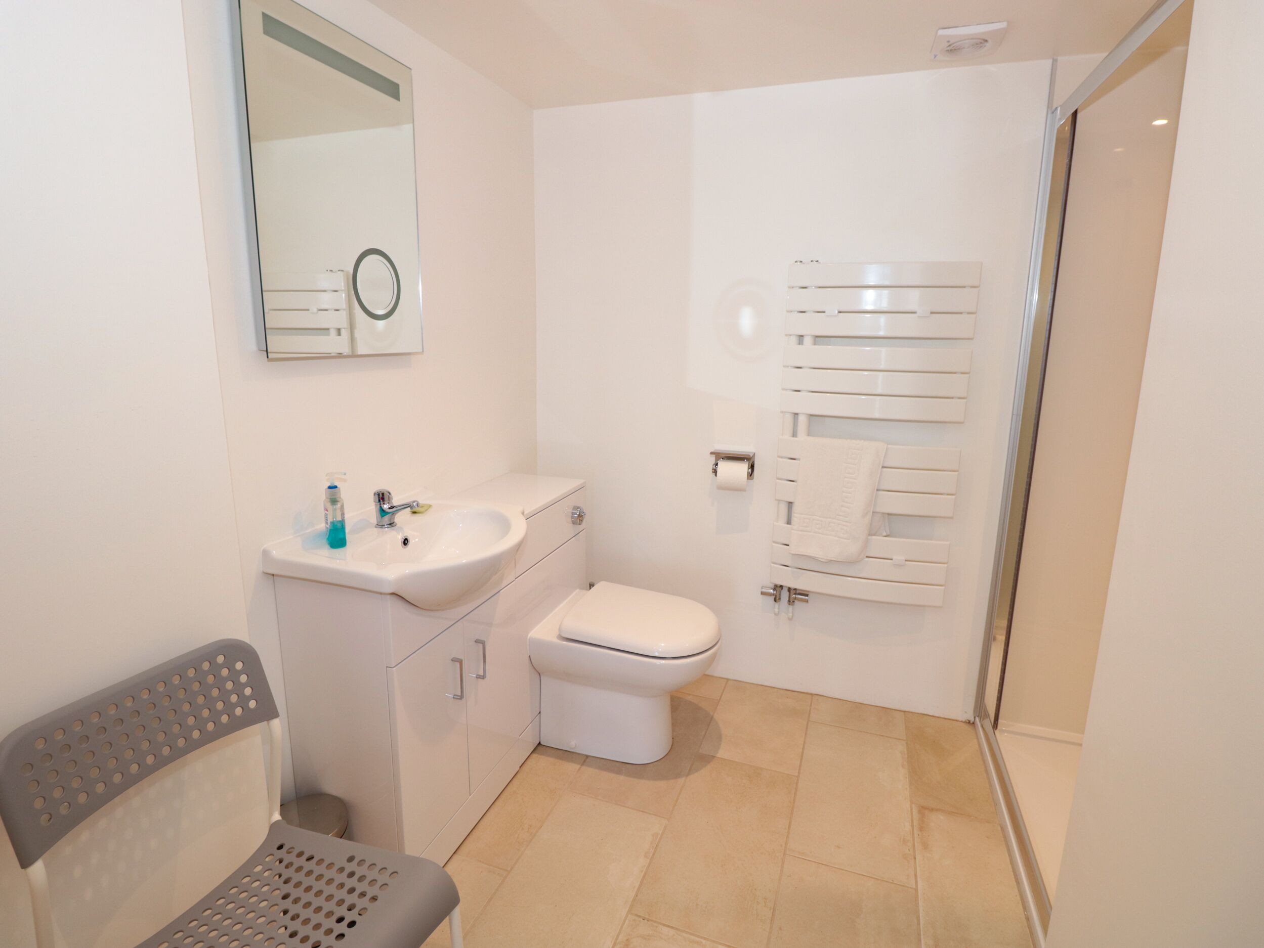 A bathroom with a sink, toilet, and towel rack.