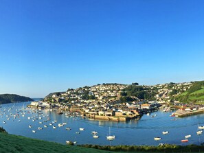 A coastal town with a marina filled with boats, surrounded by residential buildings and hills. - Anchor Cottage (Salcombe)