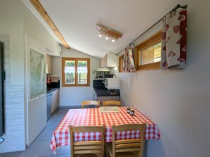 Una cocina compacta con comedor, vigas de madera en el techo y una ventana con vistas.