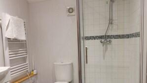 A modern bathroom with a toilet, a shower, and a towel rack. - Honeybee Cottage (Hull)