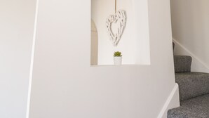 A staircase with a white wall and a heart-shaped decoration. - Y Gogarth (Tyn-y-Gongl)