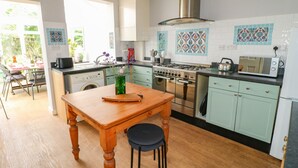 Una cocina moderna con una mesa de madera, estufa y microondas.