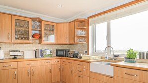 A kitchen with wooden cabinets, a microwave, a toaster, and a window providing natural light.