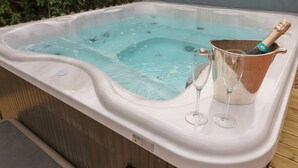 A hot tub with a champagne bottle and two glasses. - The Hen House (Rugeley)