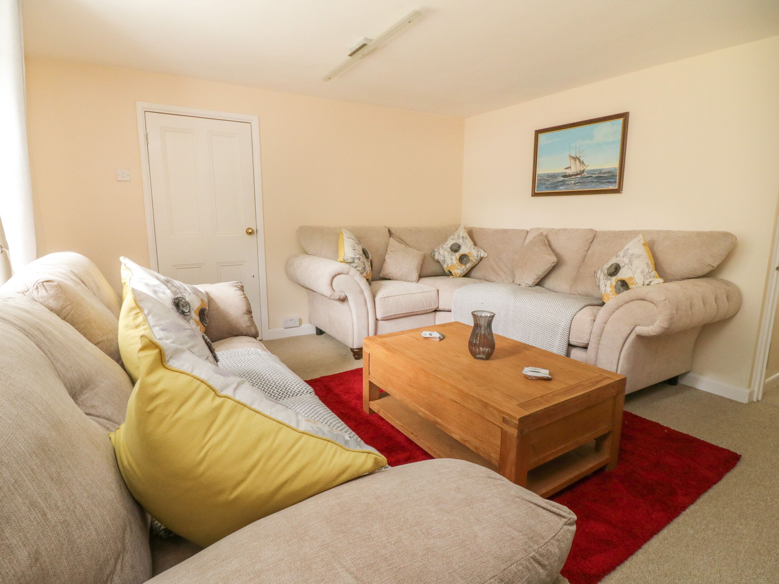 A living room with two sofas, a coffee table, and a door.