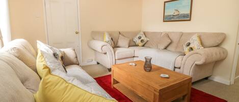 A living room with two sofas, a coffee table, and a door.