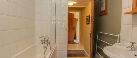 A modern bathroom with a bathtub, shower, and sink.