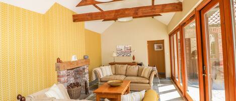 A cozy living room with a fireplace, a sofa set, and a dining table.