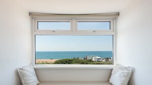 A room with a window overlooking a beach and parked vehicles. - Beach Haven (Dorchester)