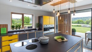 Una cucina moderna con una grande isola, un forno integrato e vista sull'esterno.