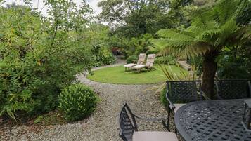 A garden with a gravel path, a lawn, and outdoor seating.