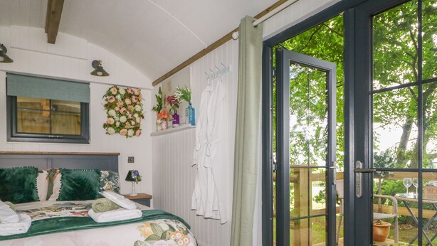 Un dormitorio con una cama, una ventana y vistas al exterior.