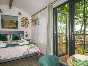 A bedroom with a bed, a window, and a view of the outdoors. - High Rigg Shepherd's Hideaway (Brampton)
