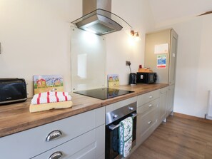 A modern kitchen with a built-in oven, a toaster, and a microwave on the counter.