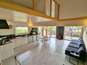 A spacious kitchen with a dining area, a sofa, and a view of the outdoors. - Charming 3-bedroom chalet with terrace near Alsace (Fraize)
