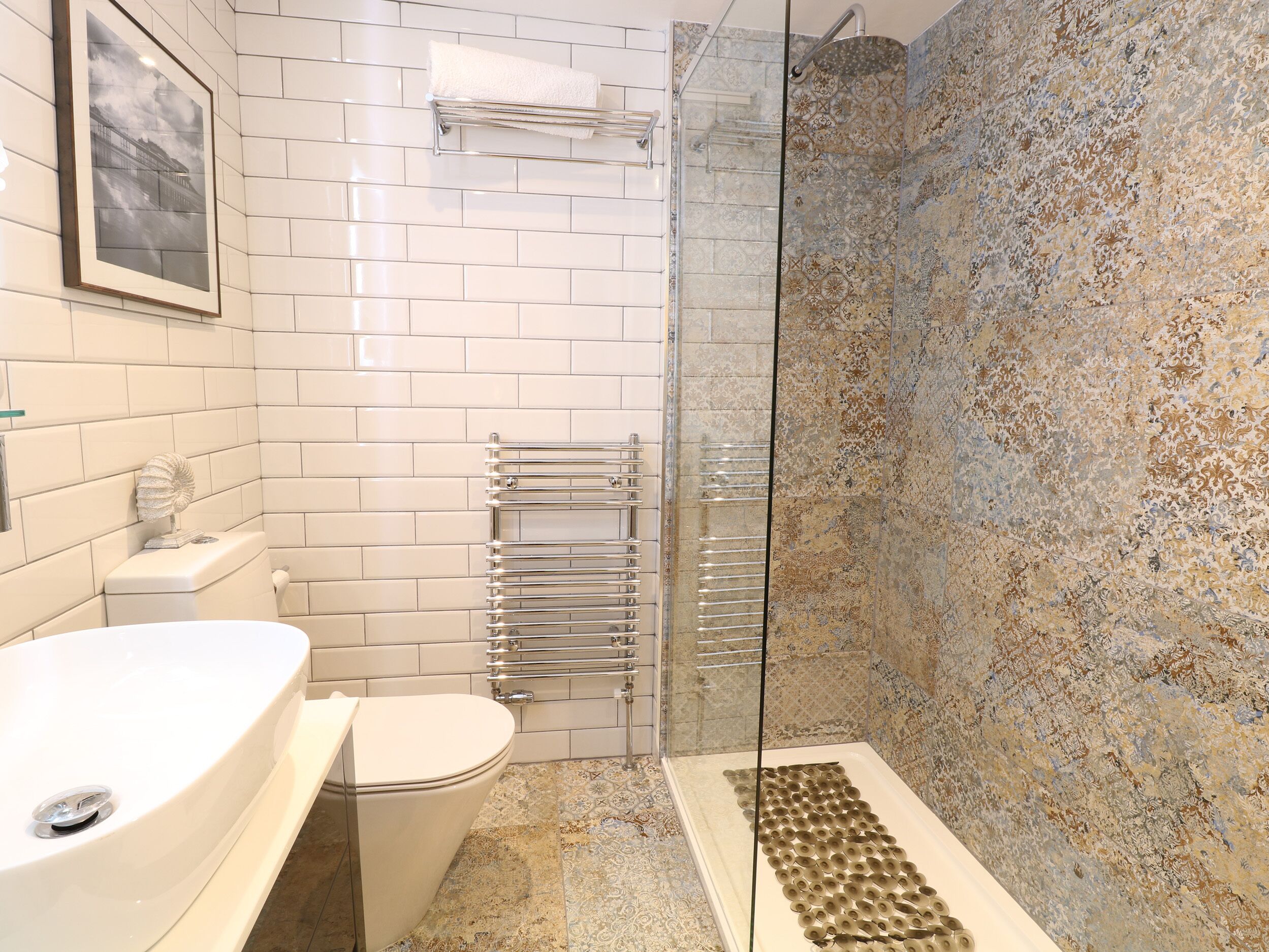 A bathroom with a white toilet, a white sink, and a glass shower enclosure.