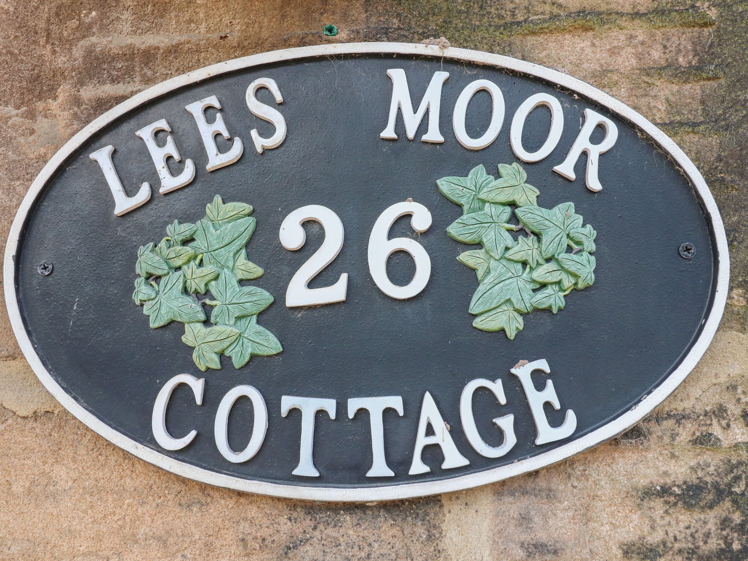 Letrero de casa para Lees Moor Cottage, con el número 26 y hojas de hiedra decorativas.
