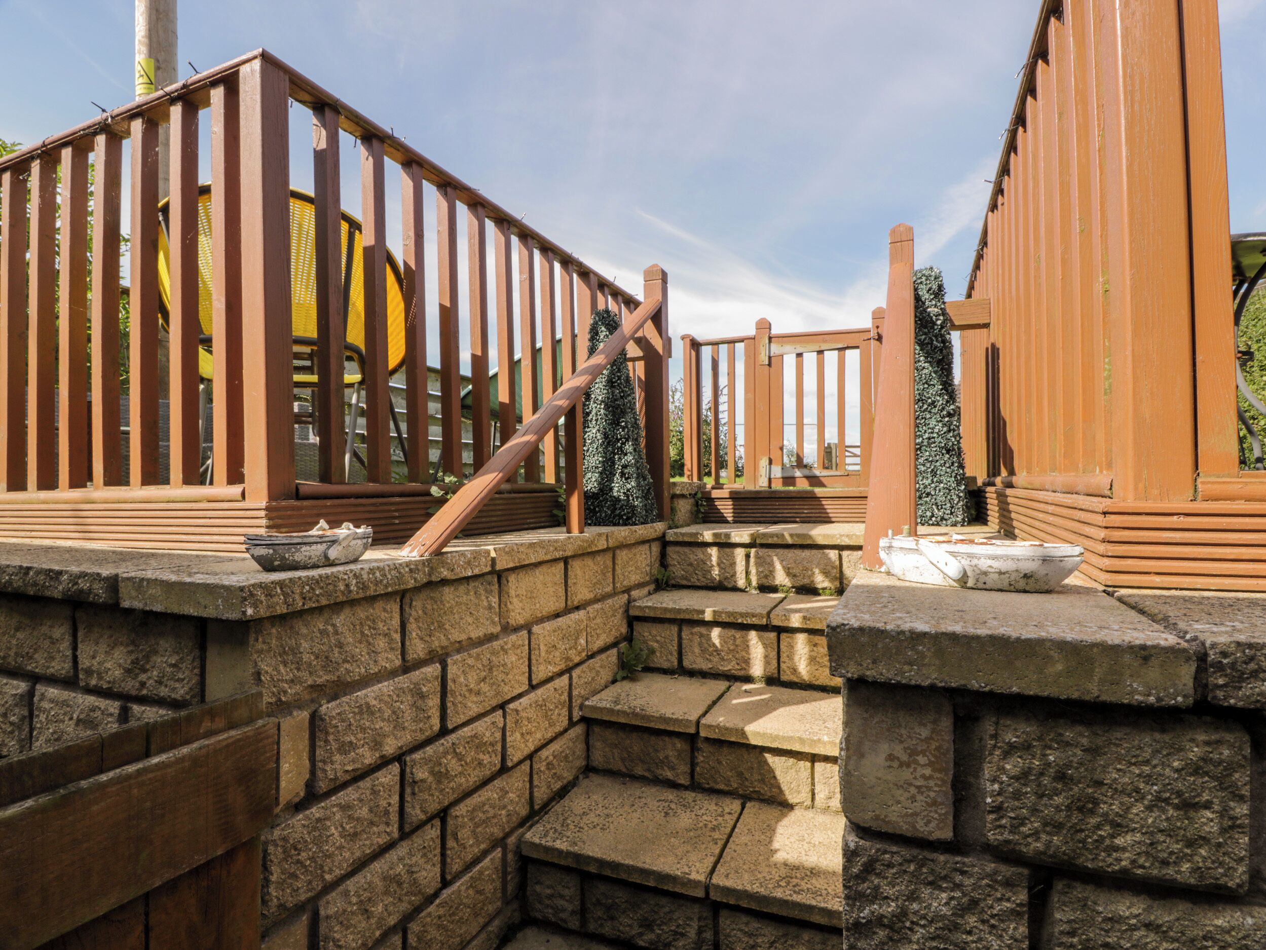 A stone staircase leading up to a wooden gate with a metal fence.