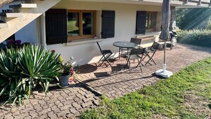 A building with a balcony, outdoor seating, and potted plants. - Cozy Mountain Retreat Near Gérardmer – Ski, Hike, Relax! (Gérardmer)