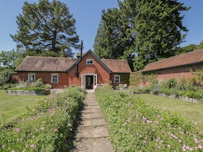 A brick house with a garden path leading to the entrance.