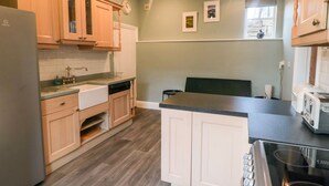 A kitchen with wooden cabinets, a dishwasher, a sink, and a stove.