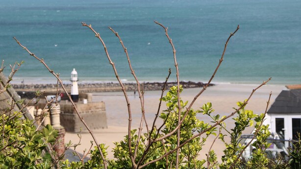 A coastal view with a lighthouse, beach, and rocky shoreline. - Little Valley View (Hayle)