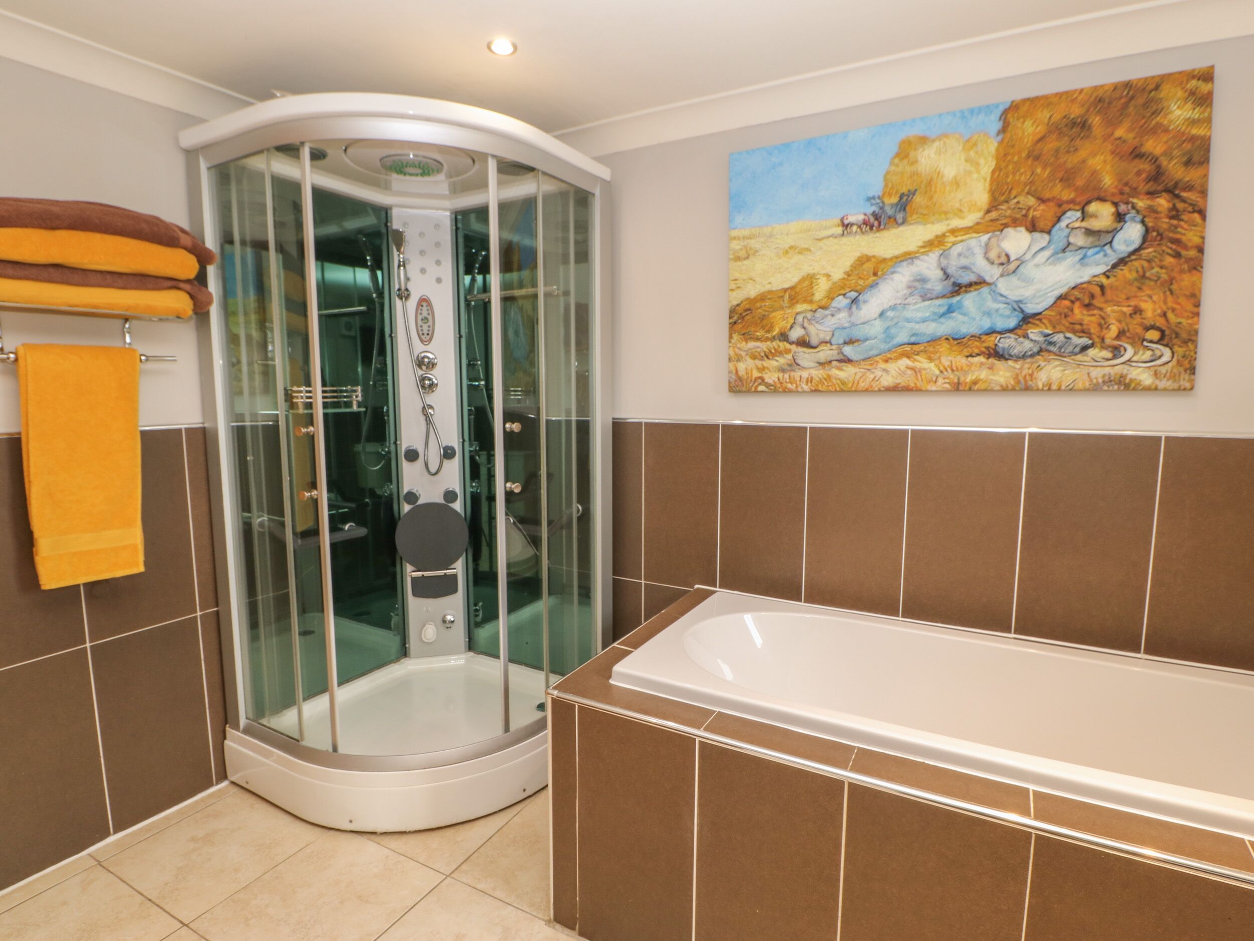 A modern bathroom with a glass-enclosed steam shower, a large bathtub, and a painting on the wall.