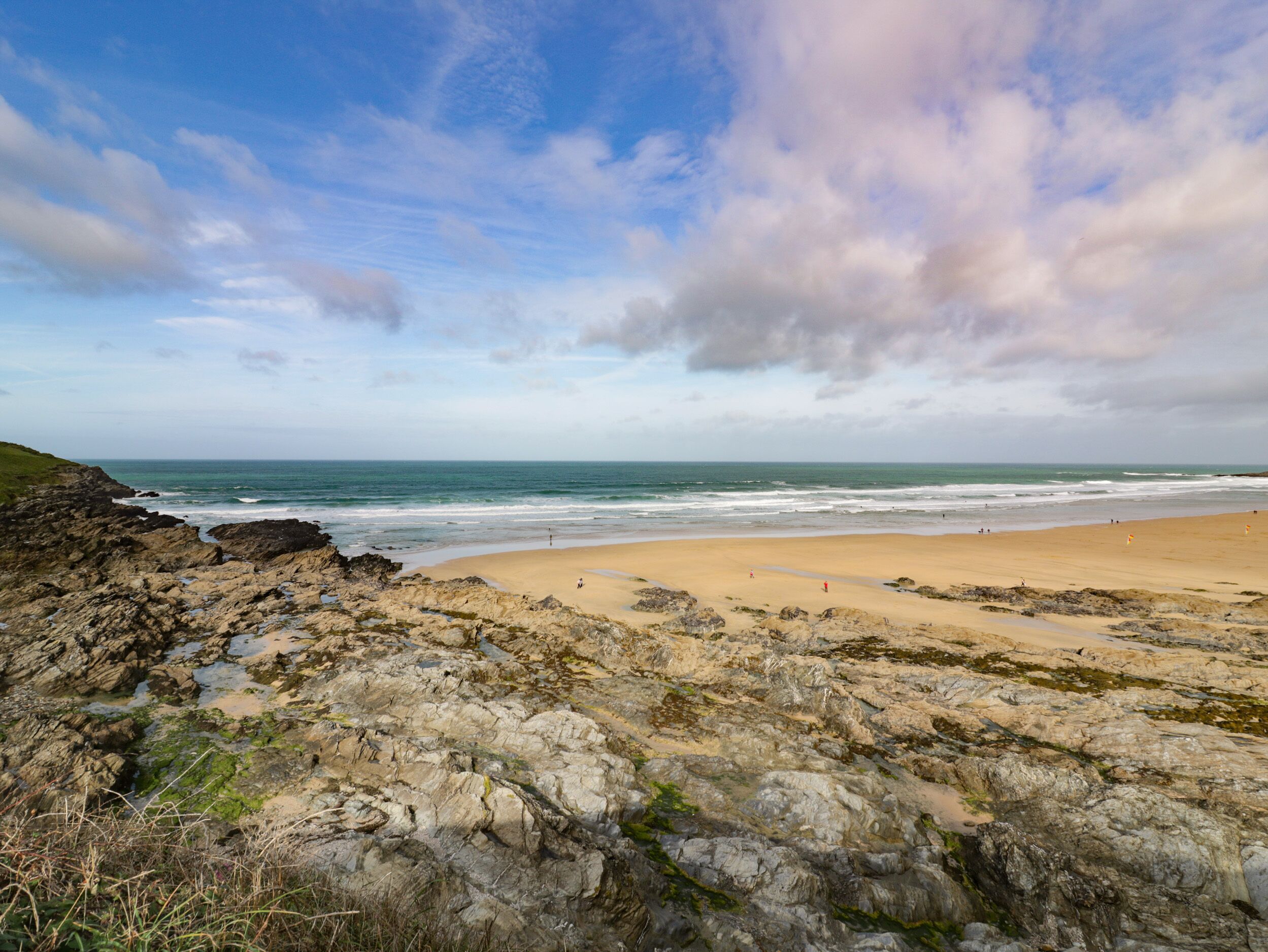 A coastal landscape with rocky terrain and a sandy beach.
