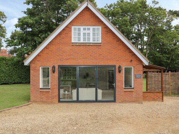 A red brick building with a gabled roof, large sliding glass doors, and a small patio area. - Thames Reach (Wallingford)