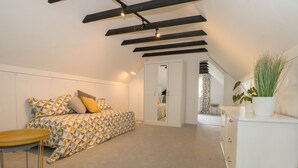 A bedroom with a bed, bedside table, wardrobe, and a potted plant. - Thames Reach (Wallingford)